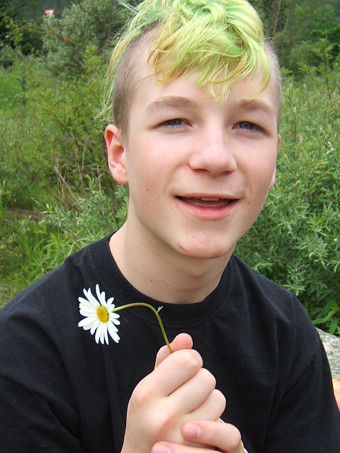 David als Jugendlicher mit hellgrünen Haaren, einer weißen Blume in der Hand und einem etwas dümmlichen Gesichtsausdruck